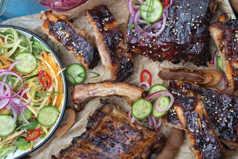 Malse BBQ spareribs met een glanzende barbecueglaze, gegrild tot ze bijna van het bot vallen.