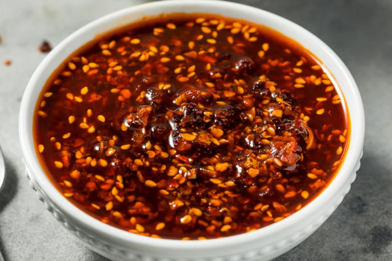 Potje zelfgemaakte crispy chili oil met chilivlokken, knoflook en knapperige stukjes in rode chili-olie.