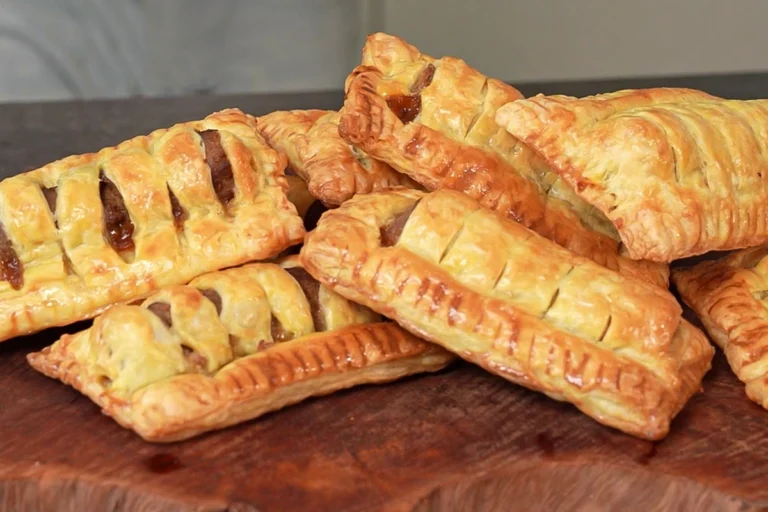 Zelfgemaakt frikandelbroodje van bladerdeeg met curry en een goudbruin, knapperig korstje.
